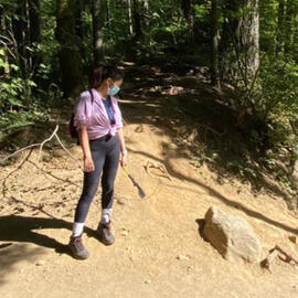 Me in hiking gear looking at a rock